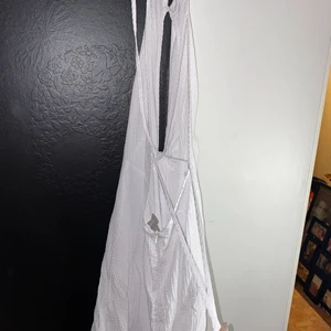 Klänning, ASOS - En vit knälång sommarklänning man knyter i ryggen så det är öppen rygg på den. Även dragkedja där bak. Super fin, använd en kväll i några timmar endast. den är i storlek 44