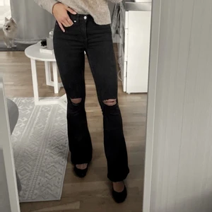 Dr.Denim - Macy ripped knees XS30 - Svarta bootcutjeans med hål på knäna från Dr Denim. Inköpspris 499kr, säljs för 150kr. Snygga byxor i bra kvalitet. 98% Bomull 2% Elastan 