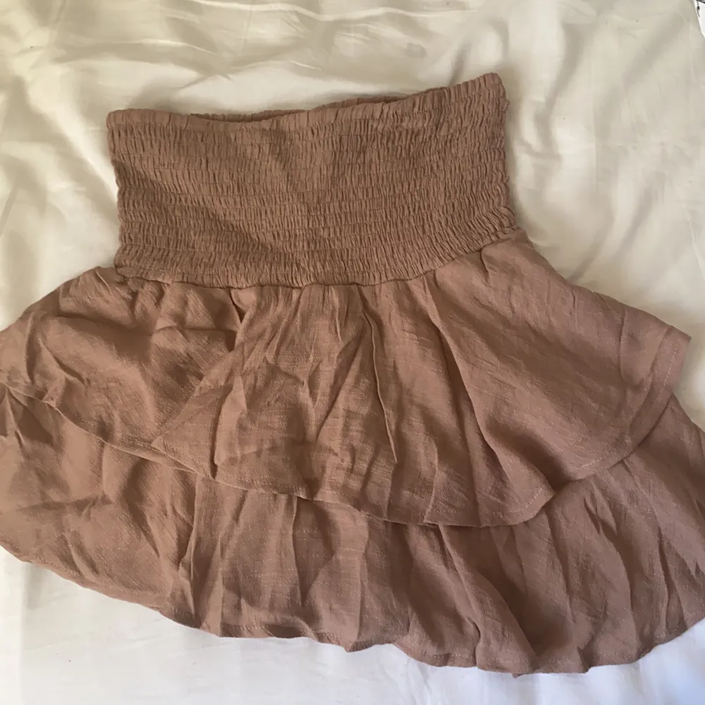 Fin beige/brun volang kjol som är snygg både som kjol och som topp nu till vinter. Köparen står för frakt! . Kjolar.