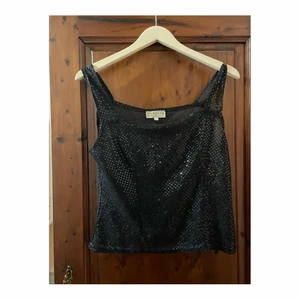 glittertopp  - en discoqueen blir du med detta svarta tunna ganska genomskinliga croppade linne, strl M/L