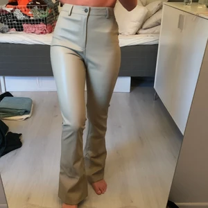 Långa läderimitation byxor ifrån motelrocks - Dessa byxor formar sig på kroppen jättefint, de är i en ljusgrön färg och köpta ifrån motelrocks!