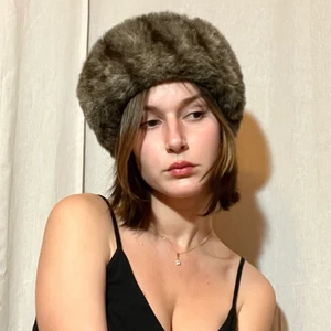 Vintage pälsmössa i fuskpäls ✨ - ✨Vill du se ut som Anastasia, glamourös och varm med gott samvete? ✨ No animal was harmed. Denna fina mössa är vintage och gjord i fuskpäls, svårfunnet men jättebra! Utmärkt skick dessutom. Mössan är i storlek S-M. Sitter ordentligt på huvudet men inte tight. Värmer bra. Har aldrig använt den ute, bara provat.  Skriv om du har någon mer fråga så kan jag beskriva mössan mer! FRAKT INGÅR I PRISET