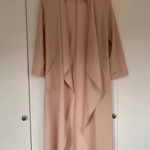 Puderrosa kappa - En tunn fin kappa i en ljus rosa färg, mer åt puderrosa eller beige. I storlek 36 från märket atmosphere.