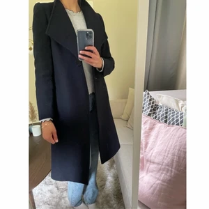 Ullkappa - Marinblå ullkappa med grym passform. Storlek M men skulle säga att den också passar en S beroende på hur man vill att den ska sitta. Kan bäras/knäppas på olika sätt beroende på hur man vill att den ska sitta/vara. Helt enkelt den perfekta höst/vinterkappan💕