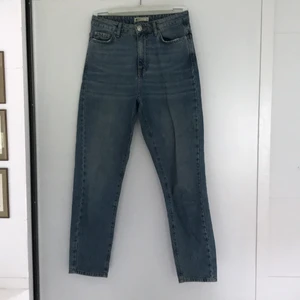 Jeans - Blåa jeans i ”mom jeans” modell från GinaTricot. Väl använda men inga synliga tecken. Köparen står för frakten, kan annars mötas upp i Stockholm.