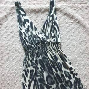 Stretchig maxiklänning i mörk leopard  med slits. 