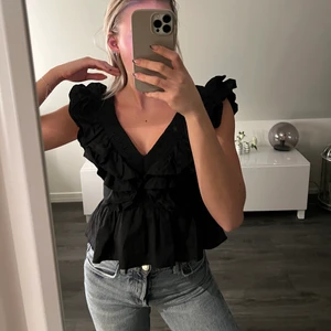 Topp med volang  - Använd 2 gånger. Sitter superfint. Urringad och djup i ryggen samt en snygg dragkedja som detalj. 