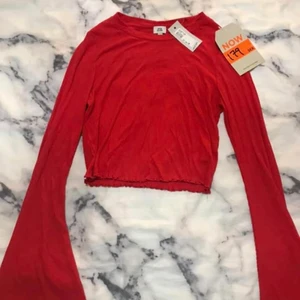Röd ribbad tröja - Röd ribbad tröja med vida ärmar på slutet. Strl 34. Aldrig använd och lappen sitter kvar.