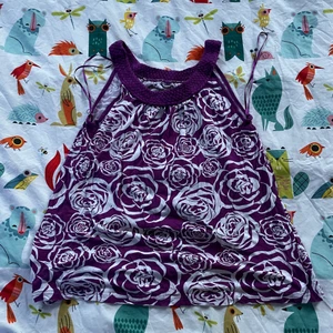 Söt topp - Säljer en söt lila topp med vita rosor och broderad runt halsen. Den är verkligen så fin men använder den tyvärr inte :( Jättefin till linnebyxor eller om man är utomlands!