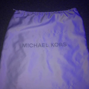 MICHAEL KORS VÄSKA - En vit Michael kors väska gjort av silke. Funkar jätte bra att ha kläder i eller annat.