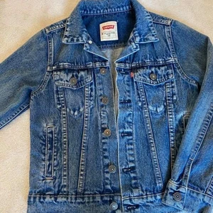 Levis jeansjacka (barn) - Jag säljer en blå jeansjacka från levis. Jackan är i väldigt bra skick då den använts ett fåtal gånger. Det är storlek 10 år som jag skulle säga motsvarar ungefär 134/140.    Köparen står för frakt.