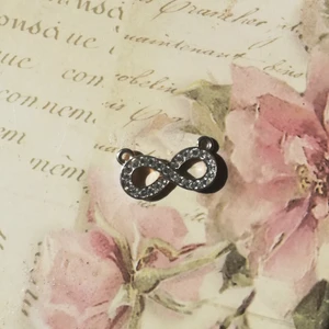 Berlock  - Superfin berlock i form av ett evighetstecken dekorerat med kristaller.