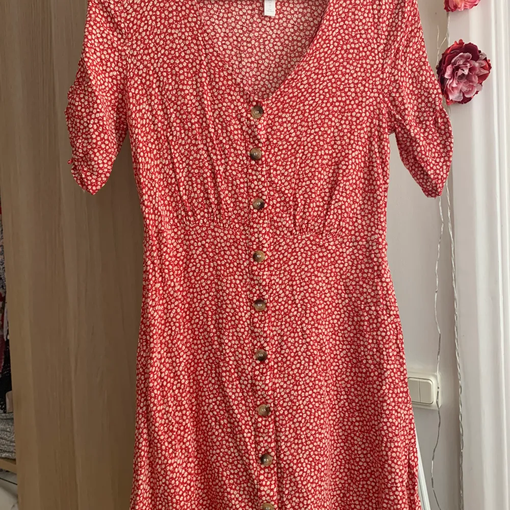 Jättefin rödblommig klänning från H&M i storlek 34. Väldigt fint skick med fina detaljer på ärmarna. Sitter superfint och är sval! 100 kr sista bilden visar hur den sitter på, den går till knäna på mig som är 160 lång!. Klänningar.