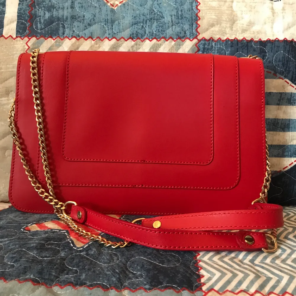 Never worn red leather bag with gold hardware. Bought from Italy. Has a small barely noticeable pen mark on the flap, please see the last photo. This could be easily covered by a pin or scarf. . Väskor.