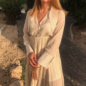 Mönstrad klänning  - Klänning i vit/beige med mönster. Använd 1 gång storlek 38.