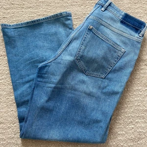 Ankellånga byxor  - Sparsamt använda ankellånga stretchiga jeans. De har högmidja och är vida i modellen. Är i storlek 40. 