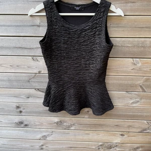 Svart peplum topp - En svart skrynklig peplumtopp med lite inslag av silver, passar S