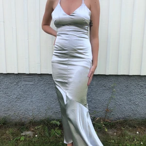 Silvrig långklänning - Klänning använd 1 gång & är i mycket fint skick🤍 korsad rygg och ankellång på mig som är 182cm. Från H&M i strl 38. Kan mötas upp eller frakta! OBS! Köpare står för frakt & betalning sker via swish 💞