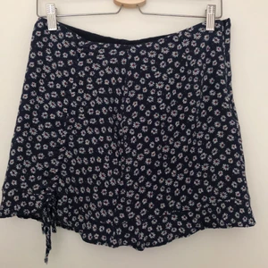 PULL & BEAR blommig kort kjol stl S - Kjolen är ganska liten i storleken. Bra skick. Knytning i höger kant. Dragkedja på sidan.