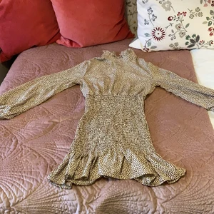 Söt klänning - Klänning med bruna hjärtan på. Storlek S. Använd endast en gång så den är i nyskick. Volang längst ner och stretch vid midjan. Liten krage. (Du betalar priset+frakt)