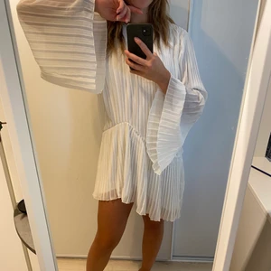 Vit klänning Nakd 34 - Vit plisserad klänning från Andrea Hedenstedt kollektion för Na Kd. Storlek 34. Vida armar.