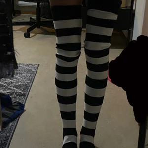 Randiga thigh highs - Svart och vit randiga thigh highs, säljer pga att jag redan har ett par likadana. Använda ett fåtal gånger men fortfarande i nyskick. De är väldigt stretchiga så de skulle kunna passa på de flesta, skriv privat för svar på ytterligare frågor!