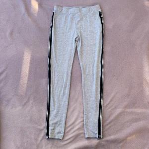 Gråa leggings från Red & Blue  - Gråa leggings byxor från Red & Blue😋Svart, vit och silvrig linjer på sidan av de💕använda ca 7-8 gånger, är i bra skick👍🏻