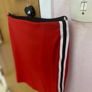 Röd mini kjol med ränder på sidan - Använd 1-2 gånger, bra skick. Strlk M
