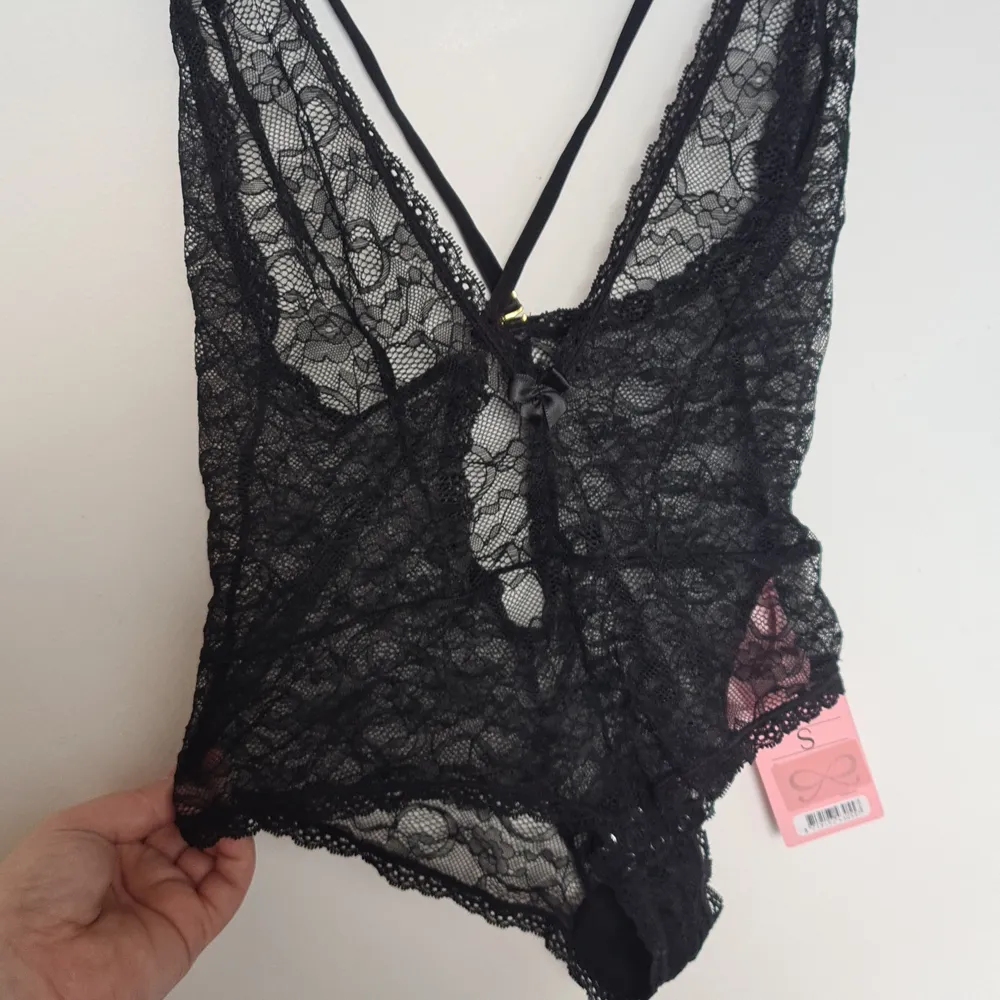 Spetsboddy från hunkemöller. Oanvänd storlek S. Guld spännen annars helt svart. Tre knappar längt ner för att öppna och stänga. Får med en pressentlåda från hunkemöller. Övrigt.