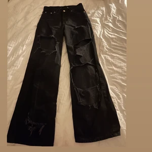 Ripped jeans - Svarta jeans från junkyard som jag har klippt hål på benen. Stl 26 men små i storleken. Bra skick. Köparen står för frakt på 66 kr.