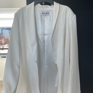 Vit kavaj - Superfin kavaj som känns/ser ut som silke i materialet, vit i färgen. Köpt från NA-KD och aldrig använt den, endast provad, alltså är den i nyskick. Storlek 36, lite overzised passform om man bär storlek 34-36 skulle jag säga :) 