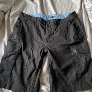 Cargo Shorts - Svarta Cargo Shorts från Dressman. Skick 10/10 (använd fåtal gånger). Storlek L passar typ 32 och 34.