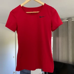 Nike träningströja - Säljer denna snyggt röda, stretchiga och svala tränings t-shirt från Nike. Sparsamt använd så är i toppen kvalitet, ser ärligt helt ny ut. Säljer pga att jag tycker den är lite för tight på mig (jag brukar ha storlek S). Storlek Xs, nypris 349. Köparen står för frakt❣️