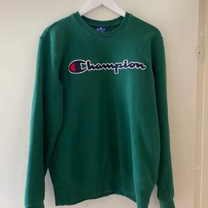 Grön sweatshirt från champion i storlek M. Köpt här på Plick för ett tag sedan men är i jättefint skick. Har vikt upp tröjan på sista bilden