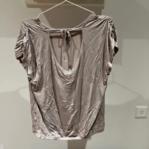 Saint Tropez tröja - Lite glittrig, rosa topp från Saint Tropez med detaljer i ryggen. Frakt priset baseras på vikten!