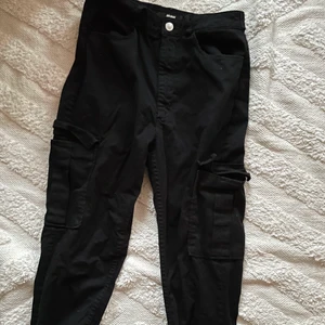 Svarta cargobyxor - Svarta cargobyxor i storlek 42 men känns mer som 38-40. Knappt använda.