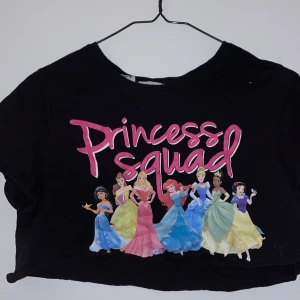 Croppad t-shirt  - En superfin svart croppad svart t-shirt med ett Disney princess tryck, den är använd ett fåtal gånger men är i jättebra skick 