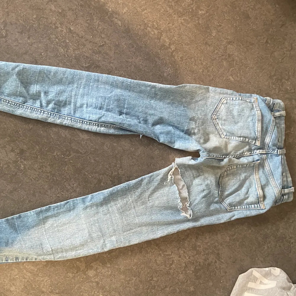 Ett par blåa jeans med hål där fram och bak på benen🤍 varit ett par favoriter faktiskt men växt ut dom nu 🤍 pris kan diskuteras . Jeans & Byxor.