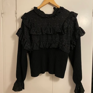 Svart stickad blus  - Säljer svart stickad blus med volangärmar från Zara. Använd 2ggr, så i bra skick förutom att bandet som fäster knappen behöver sys fast (därav det låga priset). Storlek S/M. Passformen är ganska lös, men ändå elegant.