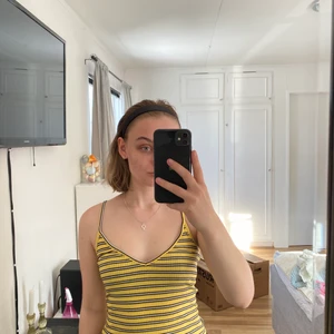 Randigt linne - Gul, vit och svart randigt linne. Har bara använts några gånger och är i bra skick.