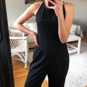 Svart jumpsuit - Svart jumpsuit med hög hals, vida ben och öppnare rygg med knytning!🌼 Frakt tillkommer😊