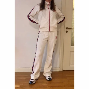 Hummel tracksuit - Jättefin tracksuit från Hummel! Vit med blå/röda revärer. Båda delarna är märkta storlek Large men de är snarare Medium. Jag som bär den har small och den är något stor på mig. Byxorna är långa i benen (jag är 169 cm). 