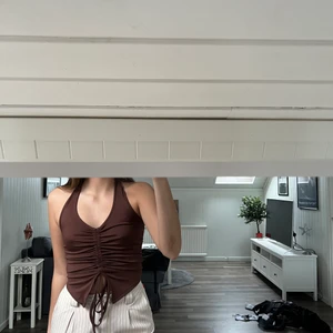 Brun halterneck - Fick den i julklapp och är bara använd 1 gång. Har en liknande tröja så känns lite onödigt att ha 2. Den är också justerbar i snörena och man kan anpassa hur cropped man vill ha den.