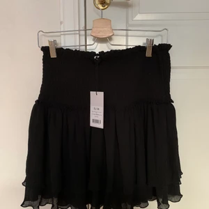 Mini structured smocked skirt - Jättefin svart volangkjol från NAKD. Säljer pga tycker den inte satt jättefint på mig. Köparen står för frakt 💘💘