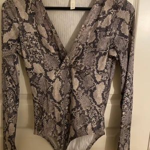 Body från HM i storleken S - Jättesnygg V-ringad body från Hm i snakeprint🤩 väldigt stretchig i materialet och funkar också på dem som använder storleken M🥰 Priset kan diskuteras! Köparen står för frakten❤️