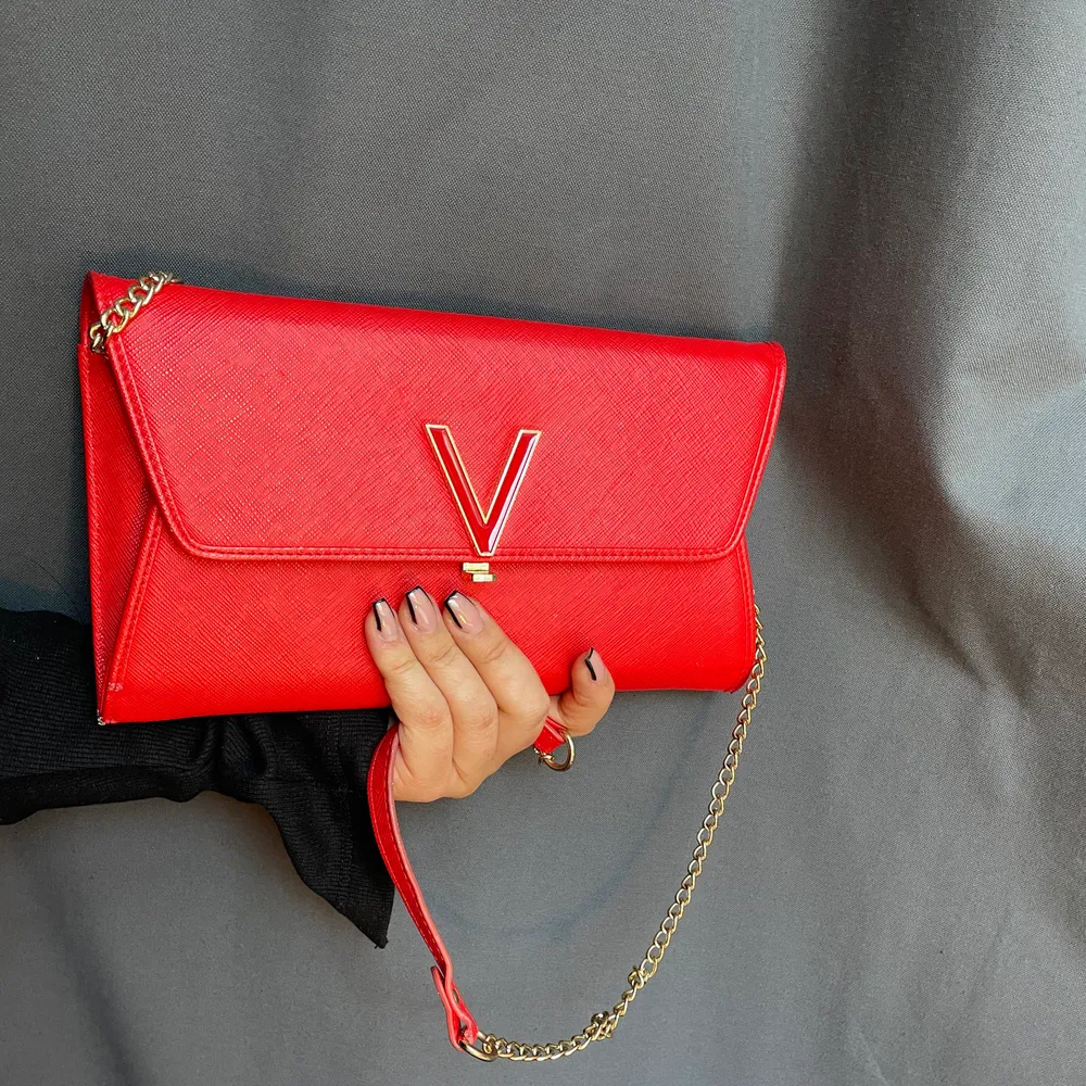Hej! Säljer denna röda brevformade valentinoväskan p.g.a flytt. Älskar verkligen färgen och de guldiga detaljer, kedjan går att ta bort (se bild två). Perfekt väska till en bal, bröllop eller festande. Det finns mycket förvaring så en plånbok behövs ej😍. Väskor.