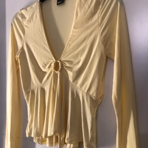 Vit gul blus/topp - En gul blus/topp, köpt från gina tricot. Använd endast en gång. Som ny. Jätte skönt material. Snörena går att spänna. 