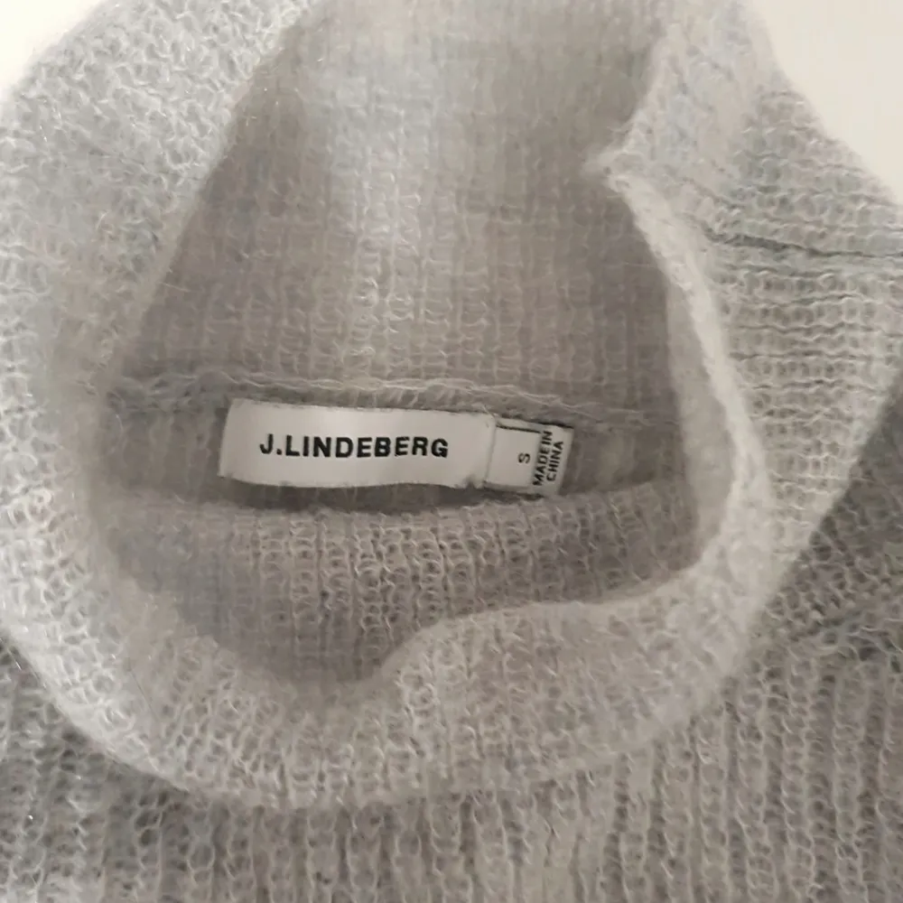 Tunn stickad tröja från J.Lindeberg för dam i storlek S. Tröjan är ljusgrå på bröstet och mörkgrå på armarna. I fint skick. . Tröjor & Koftor.
