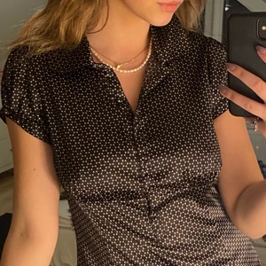 Prickig silkesblus - Säljer denna coola silkesblus! Tyhet är vitt med små täta svarta prickar. Många fina detaljer med knappar och insydd vid midjan så den framhäver formerna❤️‍🩹❤️‍🩹Den är i stl 38 och sitter även som en 38! Skriv för fler bilder eller frågor:) Köparen står för frakten📦📦