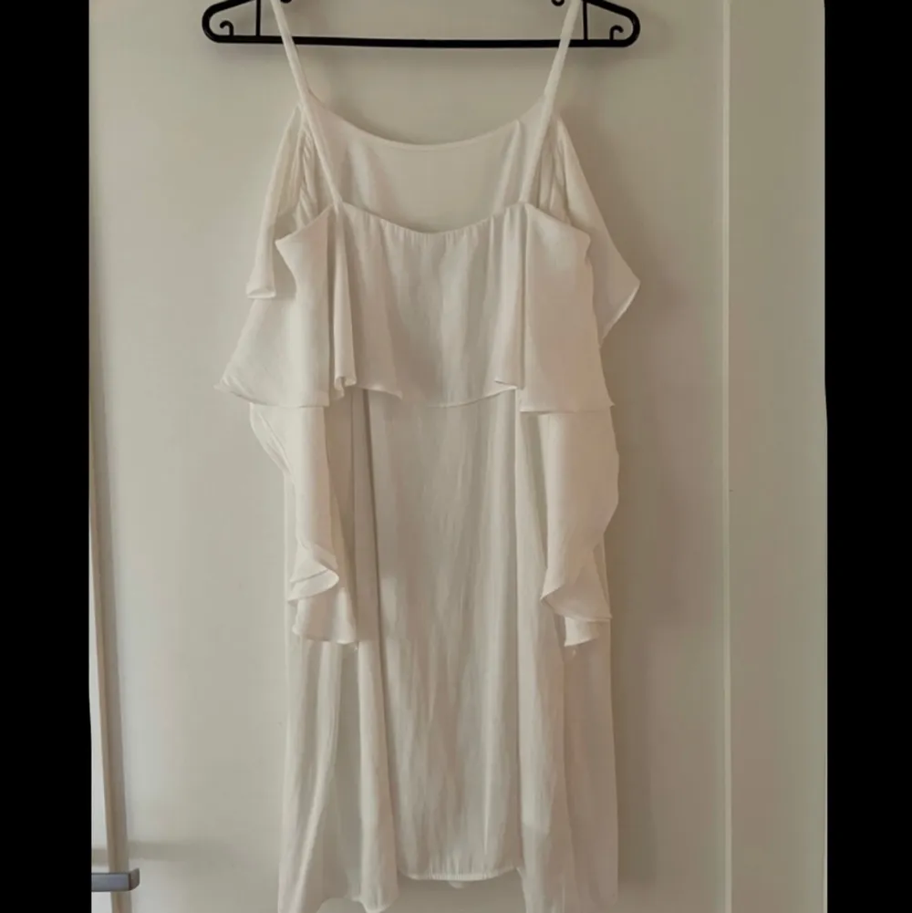 Säljer denna superfina vita klänning i strl 34/XS från MQs märke Zoul! Klänningen är fodrad, har smala axelband och en fin volang upptill som sträcker sig ned lite längs sidan💛 Den är i mycket gott skick, endast använd ett fåtal gånger💛. Klänningar.